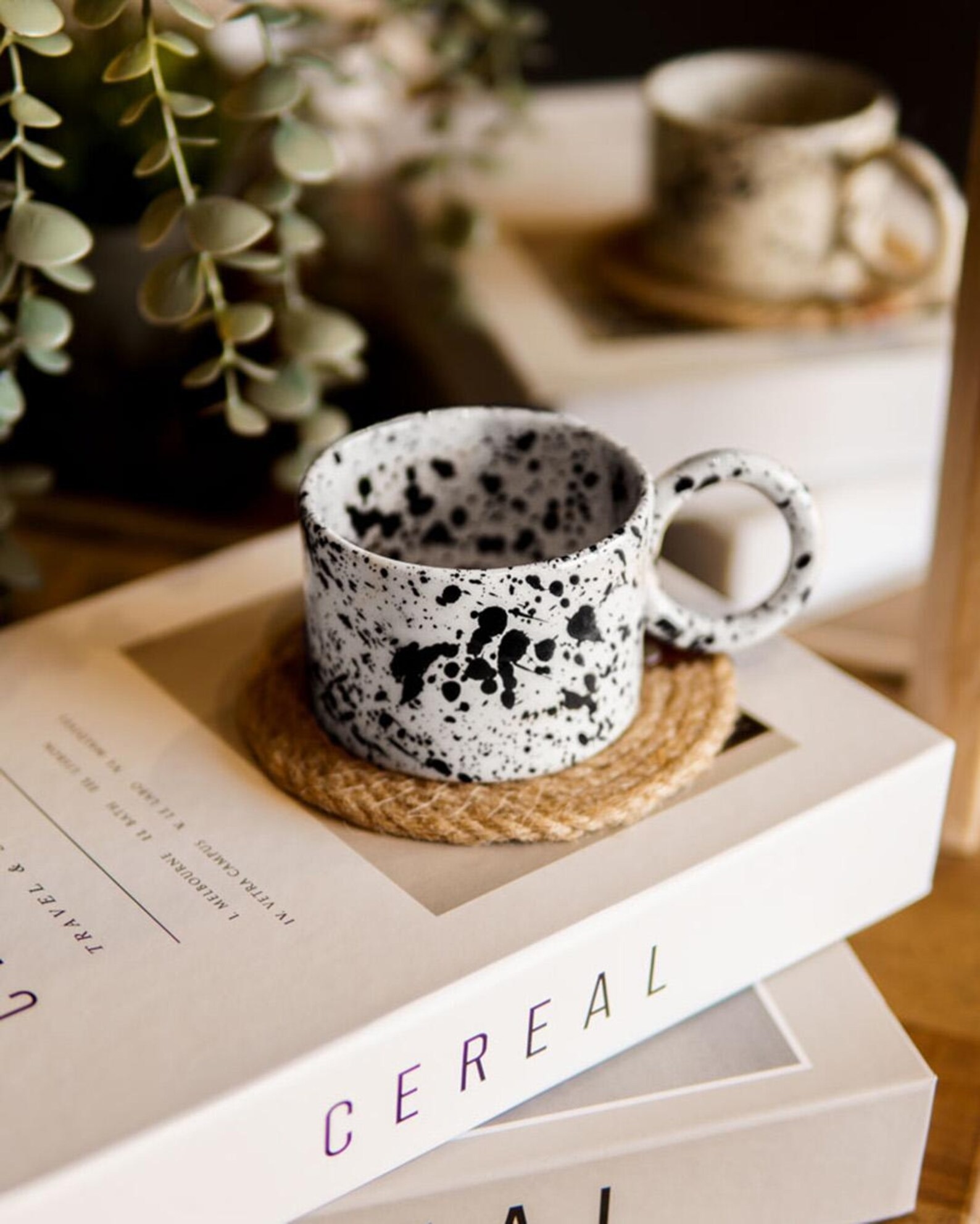White ceramic cup with black speckled splatter pattern